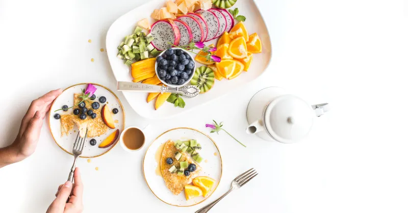 Frühstückstisch mit frischem Obst und Pancakes bei Rhesi