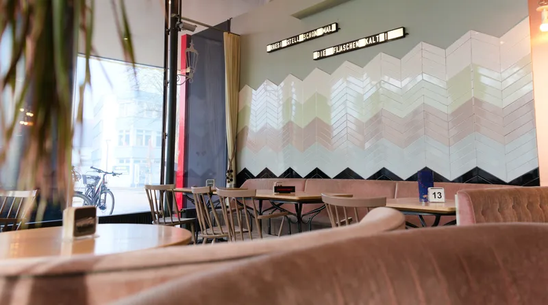 Gemütlicher Gastraum im Rhesi Café & Restaurant mit Sitzecke und Fliesenwand